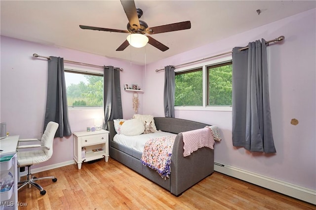 661 Wynne Dr, Coventry, OH 44319 - bedroom with a baseboard heating unit, light wood-style flooring, multiple windows, and ceiling fan