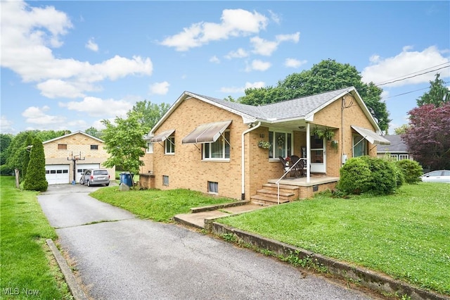 661 Wynne Dr, Coventry, OH 44319 - ranch-style home featuring a porch, a front yard, brick siding, and a detached garage