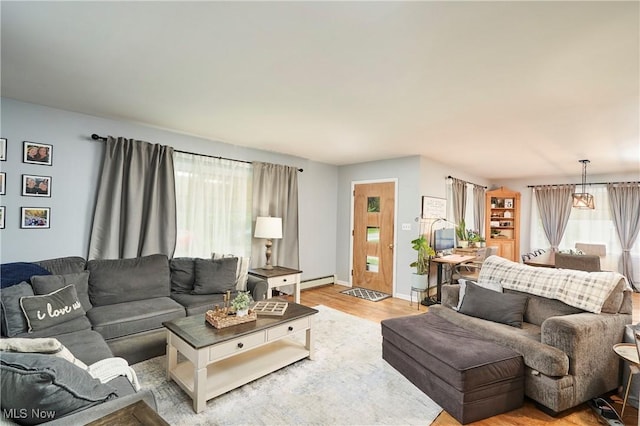 661 Wynne Dr, Coventry, OH 44319 - living area with light wood-style floors and a baseboard radiator