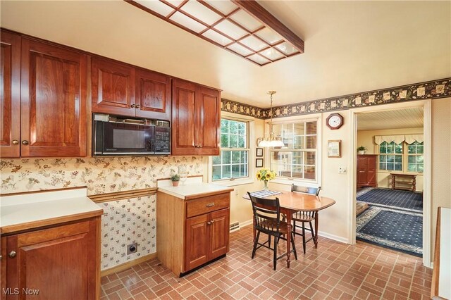11715 Dunham Rd, Sagamore Hills, OH 44067 - kitchen with black microwave, brick patterned floors, light countertops, wallpapered walls, and decorative light fixtures