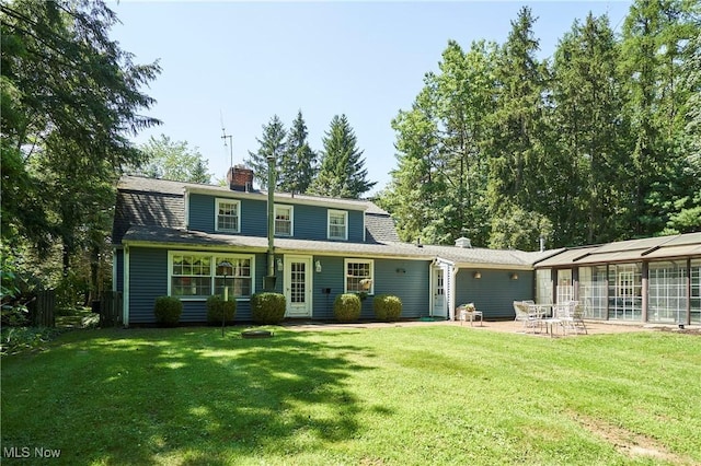 11715 Dunham Rd, Sagamore Hills, OH 44067 - view of front of house featuring a chimney, a front yard, and a patio area