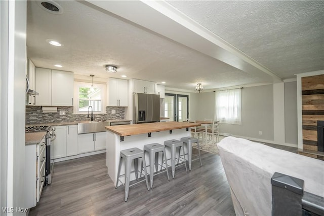 2364 Earl, Niles, OH 44446 - kitchen with stainless steel appliances, butcher block counters, a textured ceiling, open floor plan, and a kitchen bar