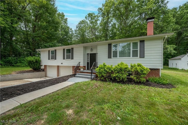 2364 Earl, Niles, OH 44446 - bi-level home with an attached garage, a chimney, a front lawn, driveway, and brick siding