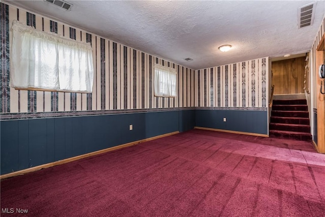 399 Abbyshire Rd, Akron, OH 44319 - carpeted spare room featuring wallpapered walls, a textured ceiling, wainscoting, and stairs