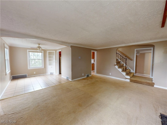 3863 Grosvenor Rd, South Euclid, OH 44118 - unfurnished living room with a textured ceiling, carpet, stairway, ceiling fan, and baseboard heating