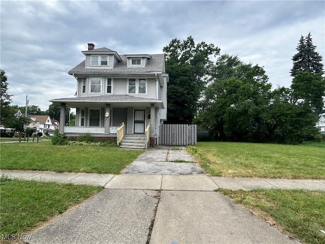 1200 E 125th St, Cleveland, OH 44112 - view of front of house featuring a chimney, a porch, driveway, and a front yard