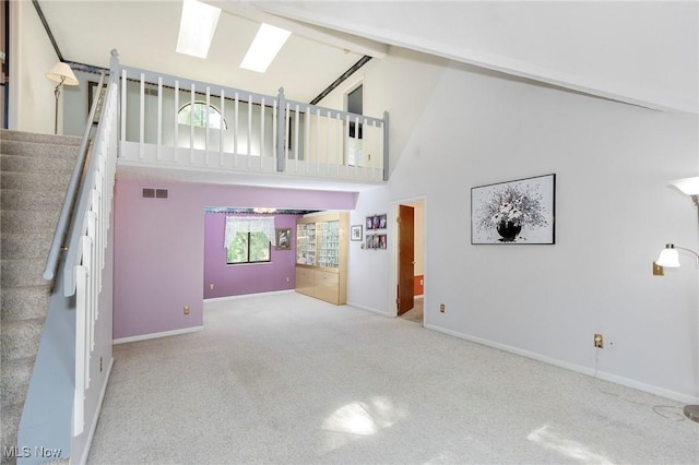 836 Arboretum Cir, Sagamore Hills, OH 44067 - unfurnished living room with a skylight, stairway, carpet floors, and high vaulted ceiling