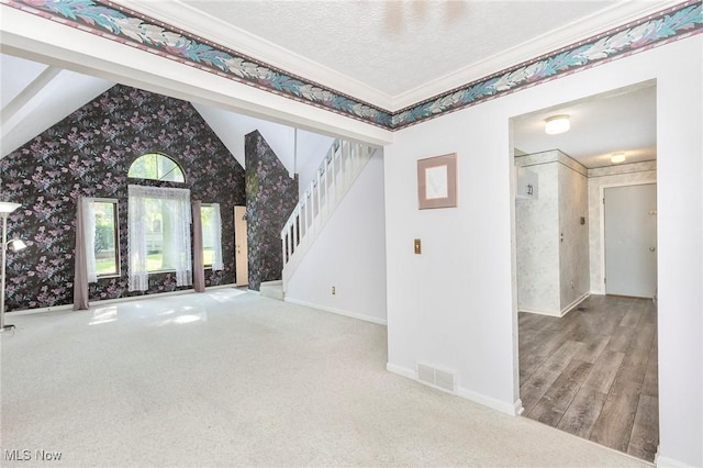 836 Arboretum Cir, Sagamore Hills, OH 44067 - unfurnished living room featuring wallpapered walls, stairway, lofted ceiling, crown molding, and carpet floors