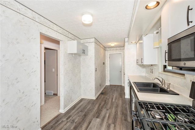 836 Arboretum Cir, Sagamore Hills, OH 44067 - kitchen featuring stainless steel microwave, gas range oven, white cabinets, dark wood-type flooring, and a textured ceiling