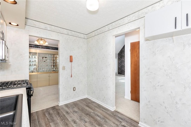 836 Arboretum Cir, Sagamore Hills, OH 44067 - kitchen with wood finished floors, gas stove, a textured ceiling, and white cabinetry