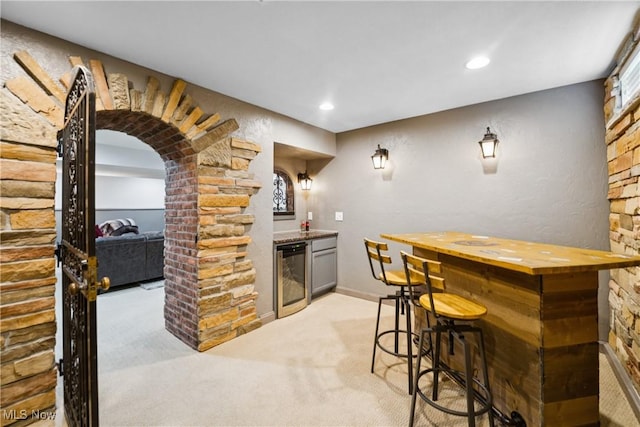 3281 Evans Way, Twinsburg, OH 44087 - indoor bar featuring wine cooler, light colored carpet, arched walkways, and recessed lighting