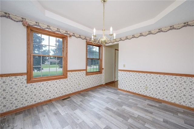 2811 Canton Rd, Uniontown, OH 44685 - unfurnished room featuring wallpapered walls, light wood-style floors, a raised ceiling, and a chandelier