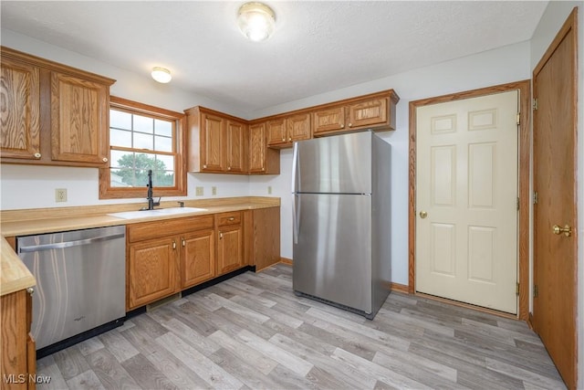 2811 Canton Rd, Uniontown, OH 44685 - kitchen featuring stainless steel appliances, light countertops, light wood finished floors, and brown cabinetry