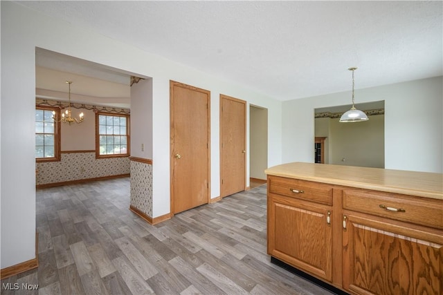 2811 Canton Rd, Uniontown, OH 44685 - kitchen with light wood-style floors, a chandelier, hanging light fixtures, and light countertops