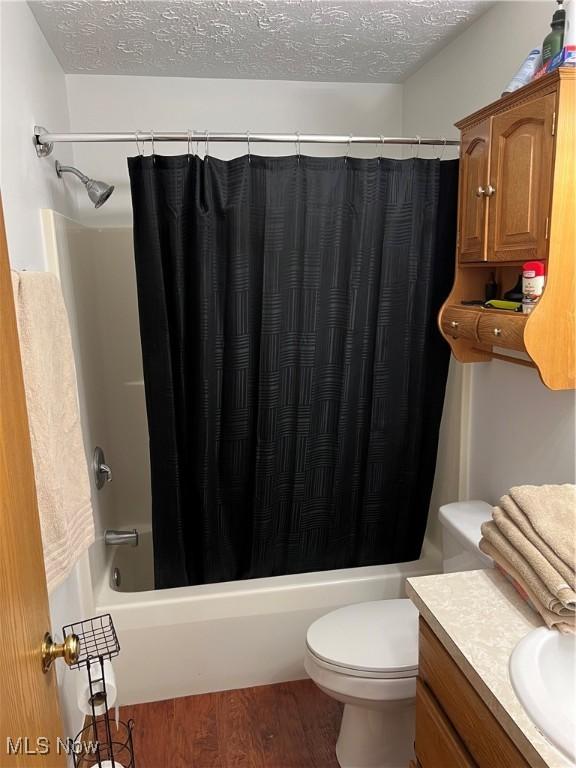 678 Highland Dr, Lodi, OH 44254 - bathroom with a textured ceiling, vanity, wood finished floors, and shower / tub combo with curtain