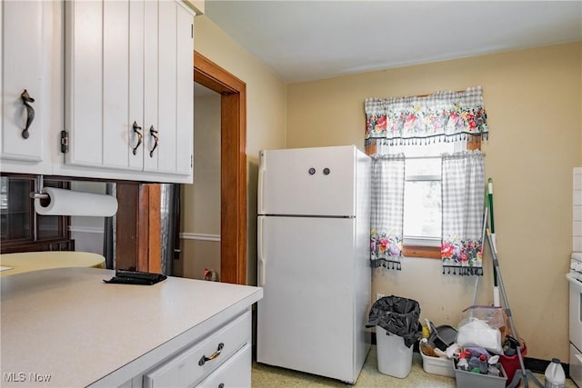 1055 W Virginia Ave, Parkersburg, WV 26104 - kitchen featuring freestanding refrigerator, white cabinetry, and light countertops