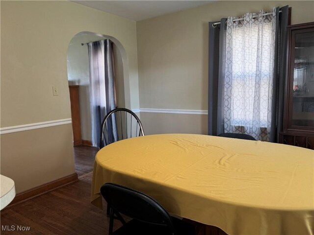 1055 W Virginia Ave, Parkersburg, WV 26104 - dining space with dark wood-type flooring and arched walkways