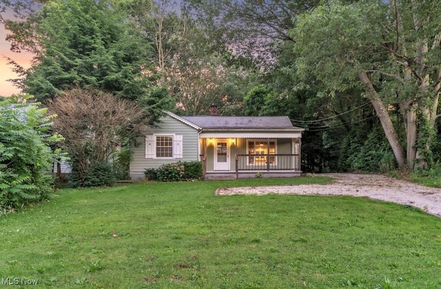 2968 Hayne Rd, Akron, OH 44312 - view of front of home featuring a porch, a lawn, a chimney, and gravel driveway