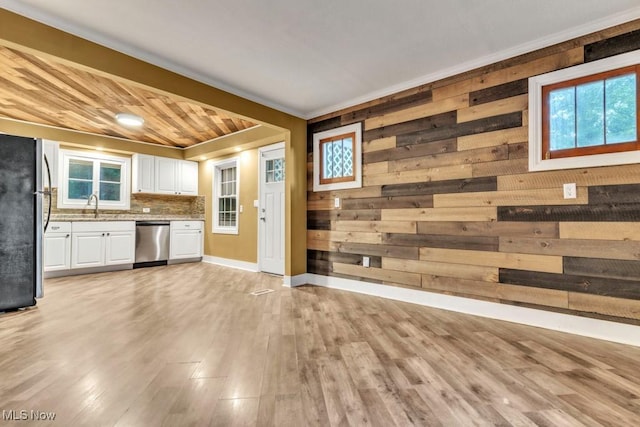 2968 Hayne Rd, Akron, OH 44312 - kitchen featuring stainless steel appliances, white cabinetry, light wood finished floors, healthy amount of natural light, and wood walls