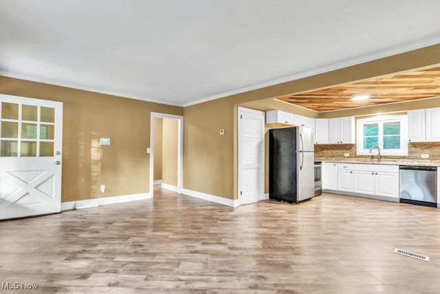 2968 Hayne Rd, Akron, OH 44312 - kitchen with stainless steel appliances, light wood-style flooring, white cabinets, ornamental molding, and decorative backsplash