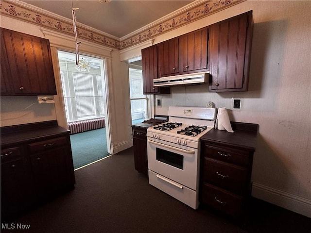 625 Main St, Caldwell, OH 43724 - kitchen with white range with gas cooktop, under cabinet range hood, dark countertops, dark colored carpet, and crown molding