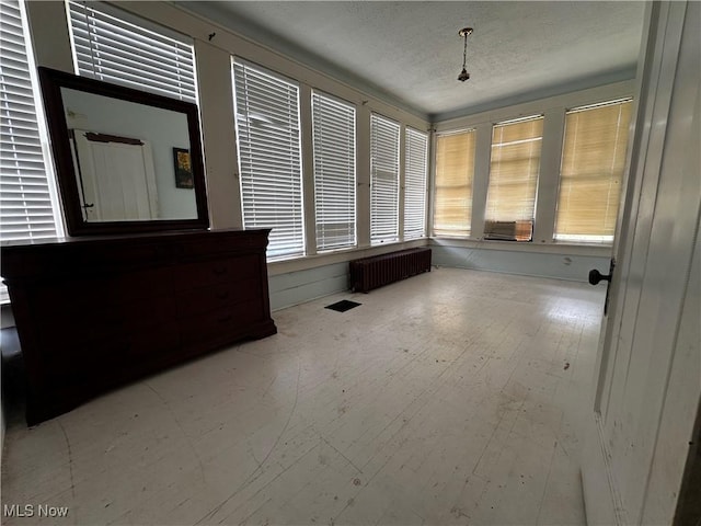 625 Main St, Caldwell, OH 43724 - unfurnished sunroom featuring radiator, a textured ceiling, wood finished floors, and cooling unit