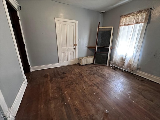 625 Main St, Caldwell, OH 43724 - unfurnished bedroom with radiator and wood-type flooring