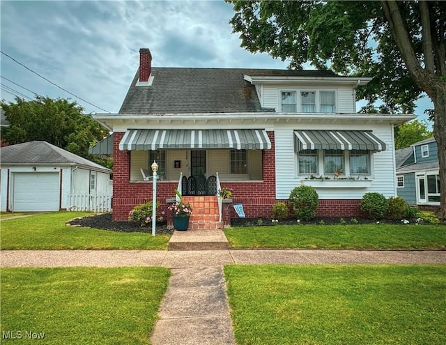 2208 Oak St, Parkersburg, WV 26101 - bungalow-style home featuring a chimney, a front lawn, a detached garage, brick siding, and a shingled roof