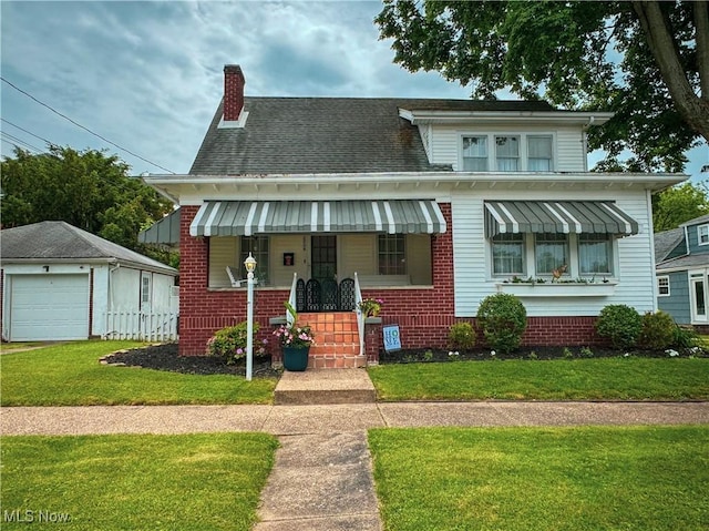2208 Oak St, Parkersburg, WV 26101 - view of front of home with a front lawn, a chimney, a porch, a detached garage, and brick siding