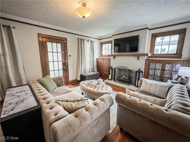 2208 Oak St, Parkersburg, WV 26101 - living area featuring a textured ceiling, wood finished floors, a fireplace with raised hearth, and ornamental molding