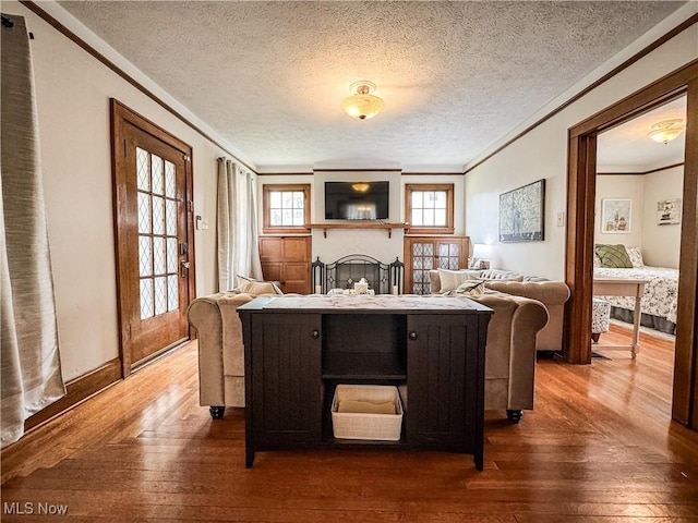 2208 Oak St, Parkersburg, WV 26101 - living area with crown molding, hardwood / wood-style flooring, a fireplace, and a textured ceiling