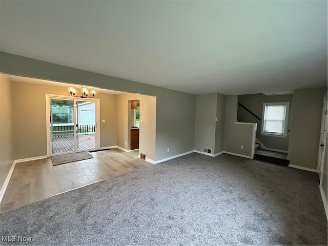 4514 Lilac Rd, South Euclid, OH 44121 - unfurnished living room with carpet floors, stairs, and a chandelier