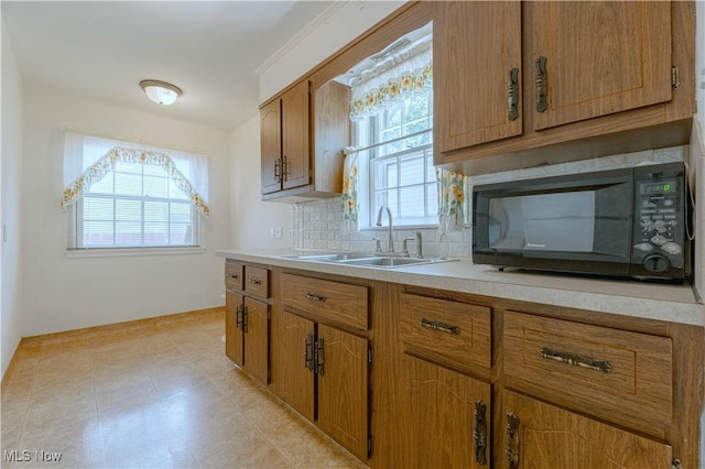 868 Davies Ave, Akron, OH 44306 - kitchen with black microwave, light countertops, backsplash, and brown cabinetry