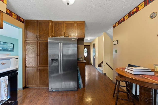 1781 Old Forge Rd, Mogadore, OH 44260 - kitchen featuring stainless steel fridge with ice dispenser, white microwave, oven, dark wood finished floors, and a textured ceiling