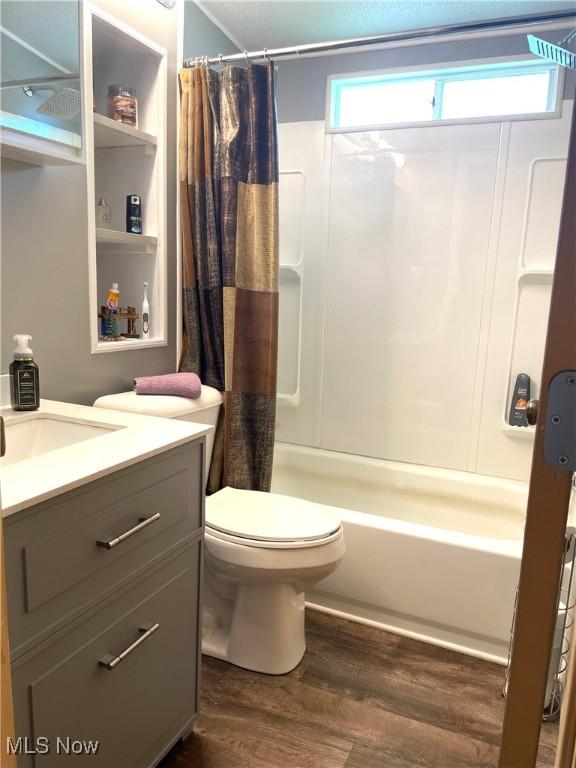 310 Jackson St, Minerva, OH 44657 - full bathroom featuring wood finished floors, vanity, and shower / bath combo with shower curtain