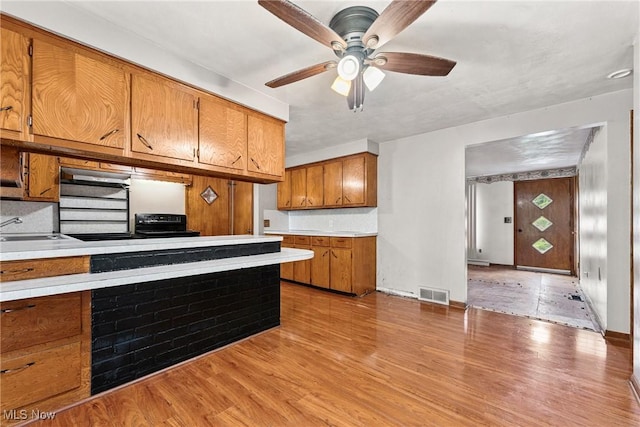 4524 Sherer Ave SW, Canton, OH 44706 - kitchen with brown cabinetry, light countertops, ceiling fan, and light wood-style floors