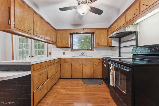 4524 Sherer Ave SW, Canton, OH 44706 - kitchen with black appliances, under cabinet range hood, light countertops, a peninsula, and light wood-style floors