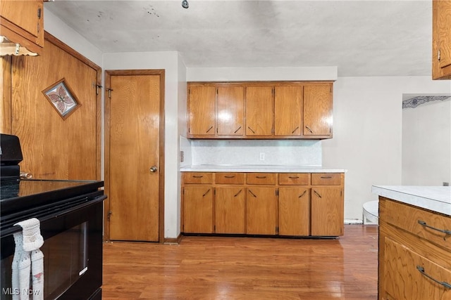 4524 Sherer Ave SW, Canton, OH 44706 - kitchen with black / electric stove, brown cabinetry, light countertops, and light wood finished floors