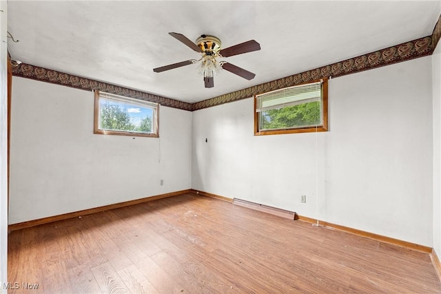 4524 Sherer Ave SW, Canton, OH 44706 - empty room featuring a baseboard heating unit, healthy amount of natural light, wood finished floors, and a ceiling fan