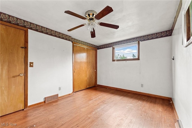 4524 Sherer Ave SW, Canton, OH 44706 - unfurnished bedroom featuring light wood-style flooring, ceiling fan, a baseboard heating unit, and a closet