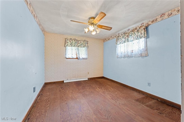 4524 Sherer Ave SW, Canton, OH 44706 - empty room with wood finished floors, wallpapered walls, baseboard heating, plenty of natural light, and ceiling fan