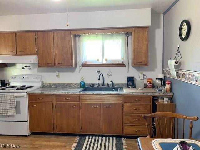 62 Township Road 245, Toronto, OH 43964 - kitchen with white electric range, under cabinet range hood, brown cabinetry, and light wood-type flooring