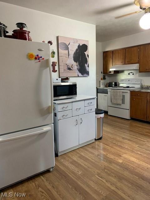 62 Township Road 245, Toronto, OH 43964 - kitchen featuring white appliances, under cabinet range hood, light wood-style flooring, and brown cabinetry
