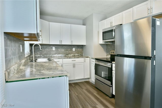 1006 Trumbull Ave, Warren, OH 44420 - kitchen with appliances with stainless steel finishes, dark wood finished floors, white cabinetry, and backsplash