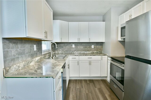 1006 Trumbull Ave, Warren, OH 44420 - kitchen featuring stainless steel appliances, dark wood-style flooring, white cabinetry, and tasteful backsplash