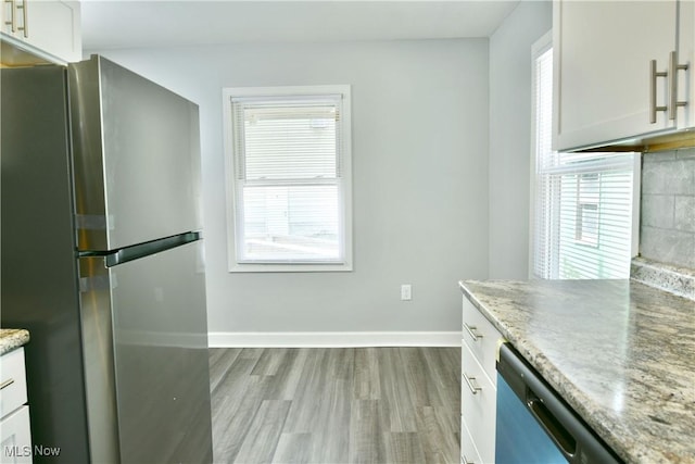 1006 Trumbull Ave, Warren, OH 44420 - kitchen featuring freestanding refrigerator, wood finished floors, dishwasher, white cabinets, and light stone countertops
