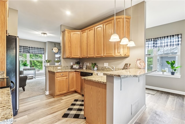 2395 Tremont Ave, Cleveland, OH 44113 - kitchen with a peninsula, stainless steel dishwasher, light wood-style floors, light stone counters, and pendant lighting