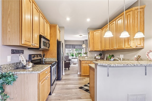 2395 Tremont Ave, Cleveland, OH 44113 - kitchen with stainless steel appliances, light wood-style flooring, a kitchen breakfast bar, a peninsula, and decorative light fixtures