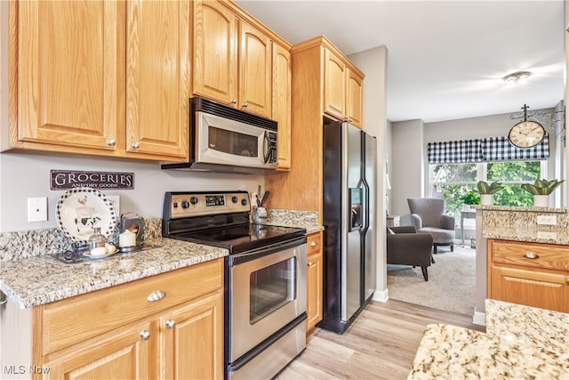 2395 Tremont Ave, Cleveland, OH 44113 - kitchen featuring stainless steel appliances, light wood-style floors, light stone counters, and light brown cabinetry