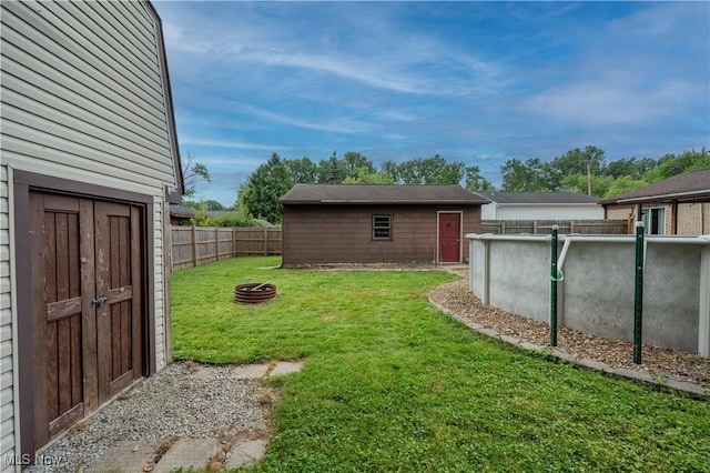 1291 Woodhurst Dr, Austintown, OH 44515 - fenced backyard with a fire pit and an outdoor structure